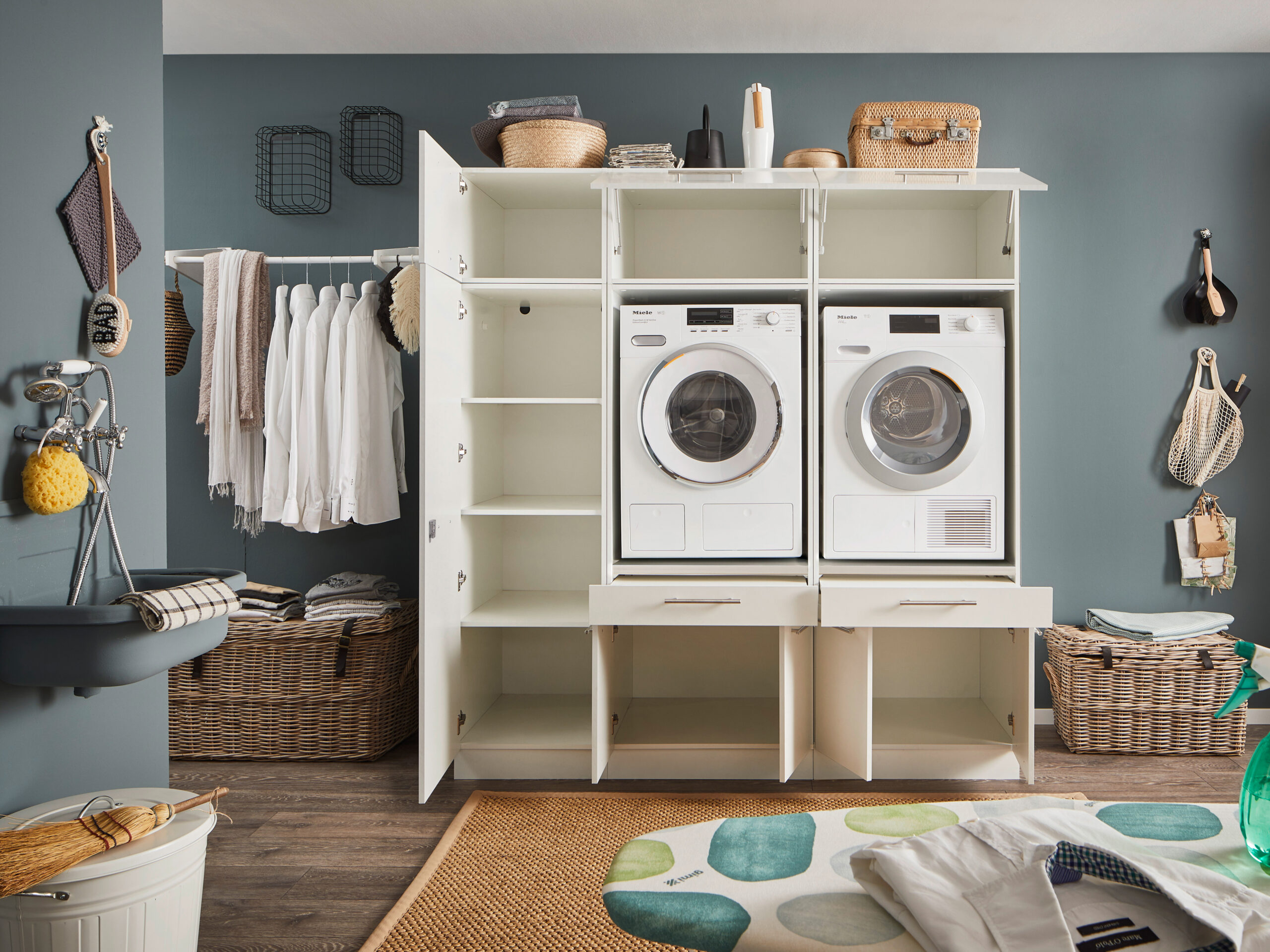 Laundreezy LDSK13W Milieu offen_91-222-17_70-202-17+37-201-17+70-200-17+37-202-17 Offene weiße Schranklösung mit integriertem Waschmaschinen Turm und großzügigen Staufächern im Hauswirtschaftsraum.