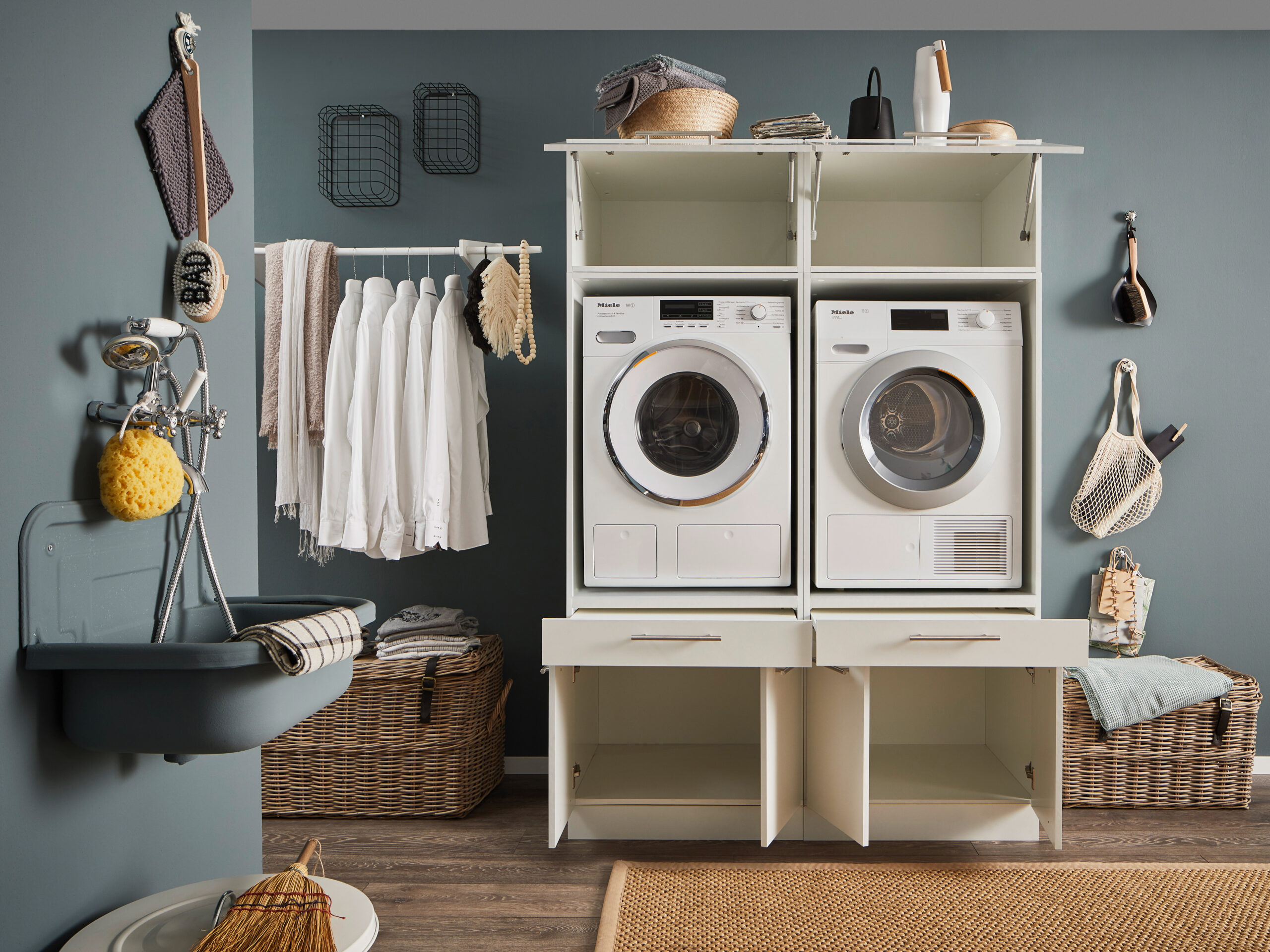 Offenes Doppelmodul in Weiß mit zwei eingebauten Geräten und geöffneten Stauflächen im Hauswirtschaftsraum.