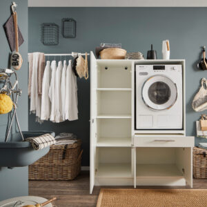 Geöffneter weißer Waschmaschinen Schrank mit seitlichen Regalfächern und unterem Stauraum in moderner Waschküche.